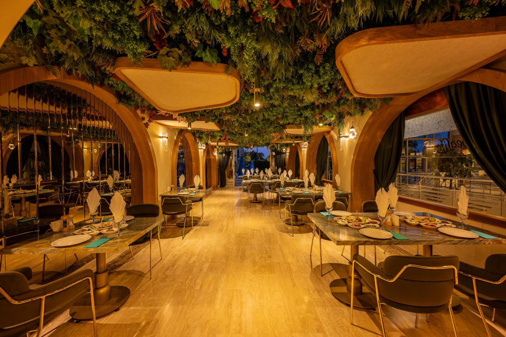 Sealife Family Resort Hotel tematiskais restorāns ar bagātīgu griestu apstādījumu dekoru, koka arkām un eleganti klātiem galdiem vakariņām