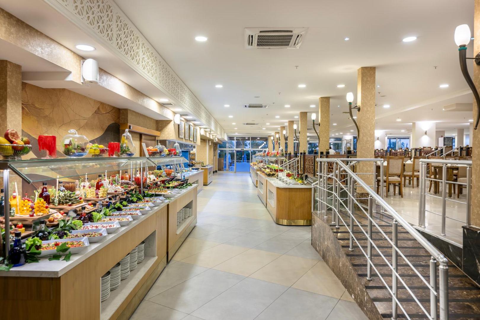 Sealife Family Resort Hotel galvenā restorāna bufetes zona ar plašu uzkodu, salātu un augļu izvēli gaišā, modernā interjerā