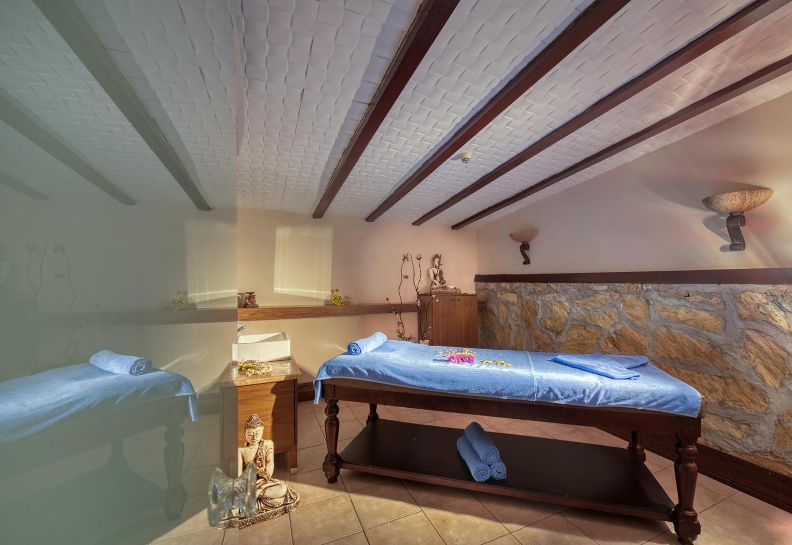 Mājīga masāžas telpa Sealife Family Resort Hotel spa zonā ar koka elementiem, masāžas galdu un Budas statuju