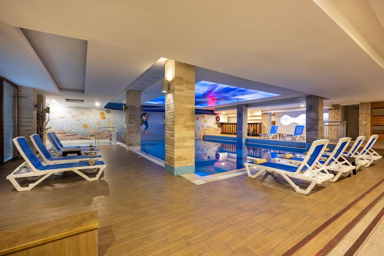 Sealife Family Resort Hotel iekštelpu baseins un SPA zona — atpūtas krēsli, dekoratīvas mozaīkas un mierīga atmosfēra relaksācijai