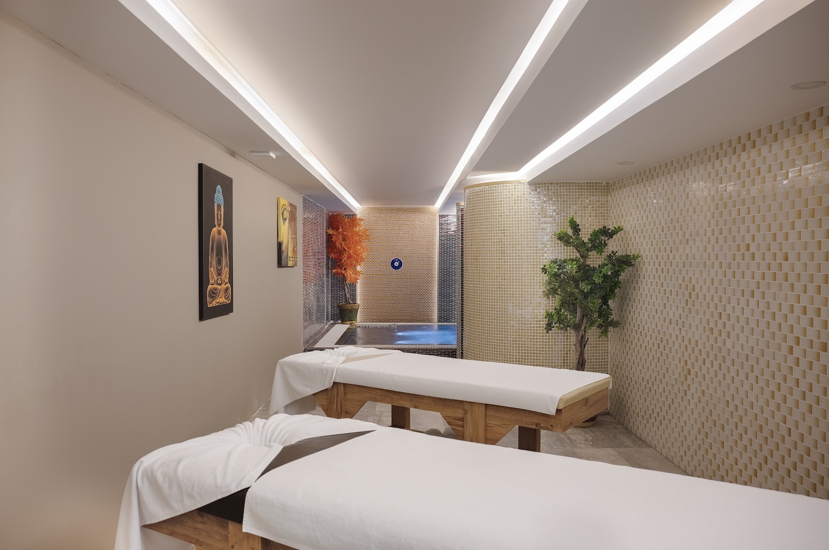 Sailor's Beach Club spa centra masāžas telpa ar divām kušetēm, mierīgu apgaismojumu un nelielu baseinu fonā