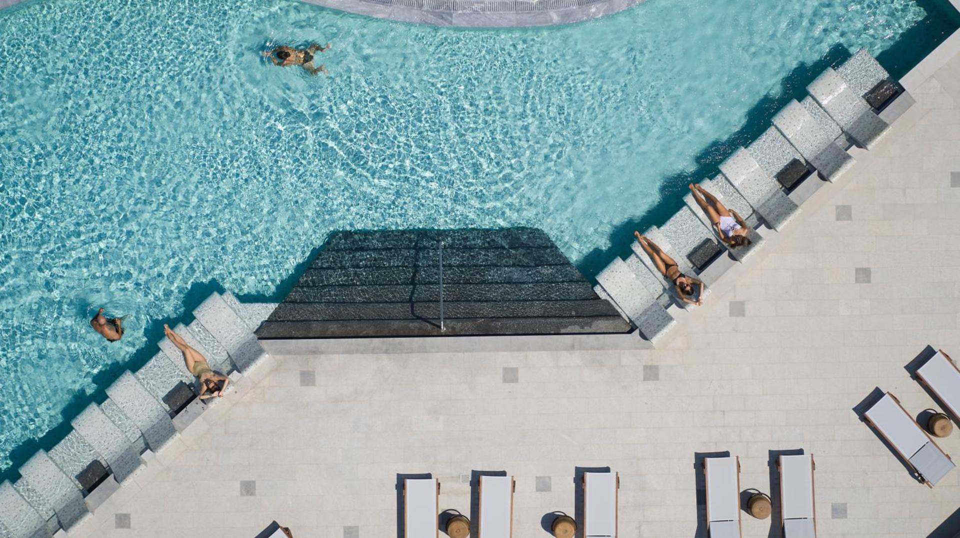Cayo Exclusive Resort and Spa skats no augšas uz galveno baseinu ar tirkīzzilu ūdeni un atpūtas zonu Elundā, Krētā