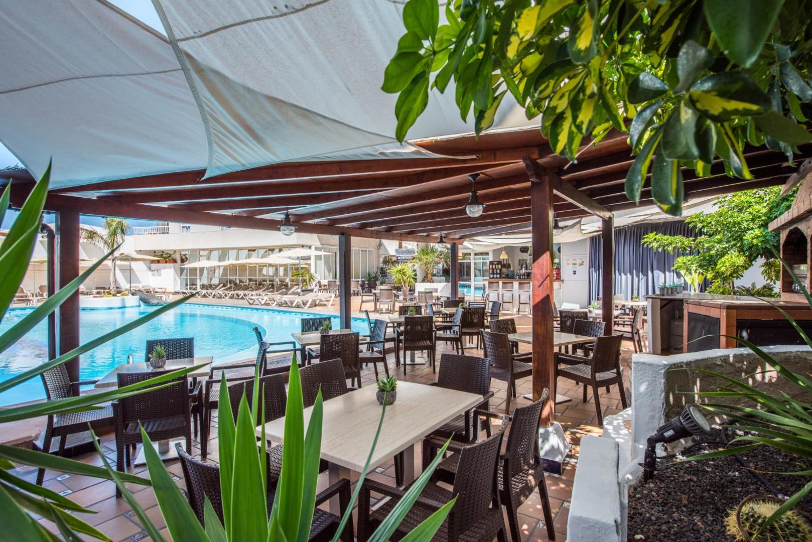 Vigilia Park Apartamentos āra terases restorāns pie baseina ar koka nojumi un modernām mēbelēm Tenerifē