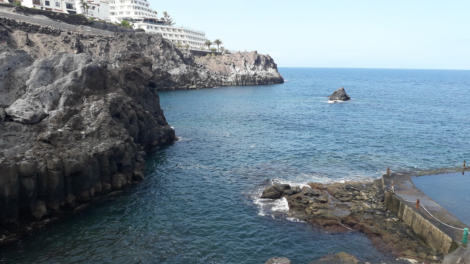 Vigilia Park Apartamentos apkārtnes klinšainā piekraste ar dabisko baseinu un skatu uz okeāna zilajiem ūdeņiem Tenerifē