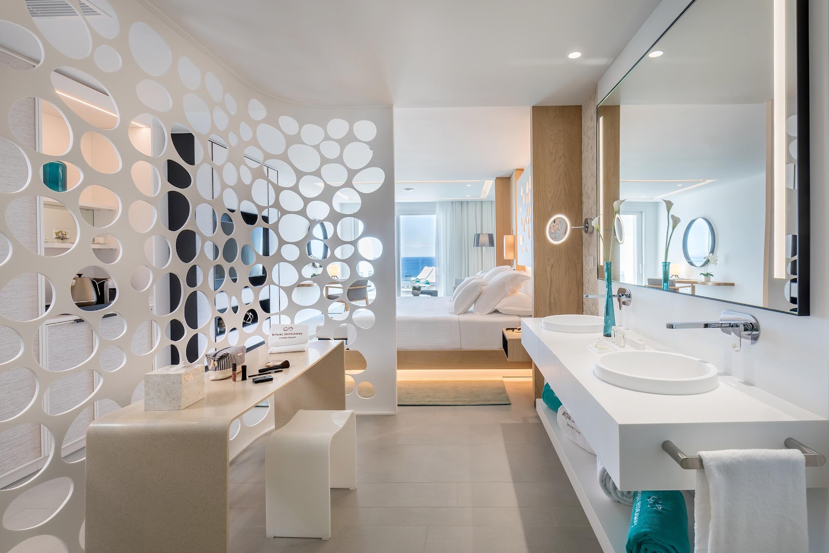 Gaišs un moderns Royal Hideaway Corales Suites numurs ar atvērtā plānojuma vannasistabu, dizaina starpsienu un skatu uz okeānu