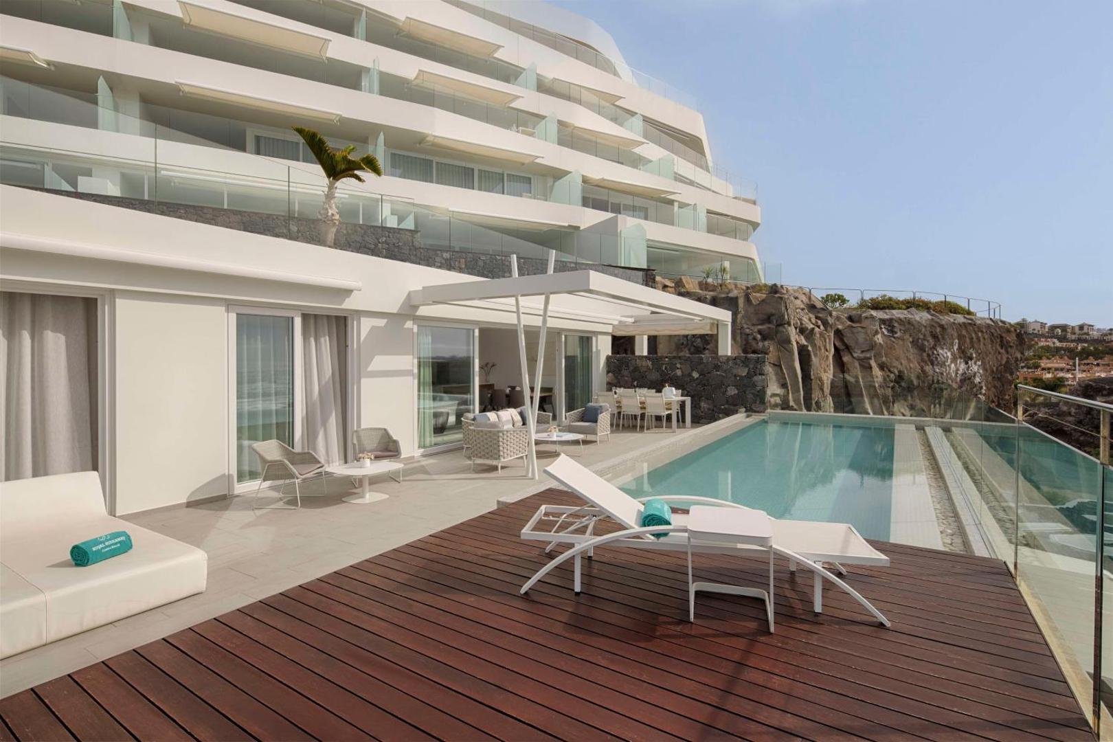 Royal Hideaway Corales Suites numurs ar tiešu piekļuvi baseinam un koka terasi piekrastes klintīs Tenerifē