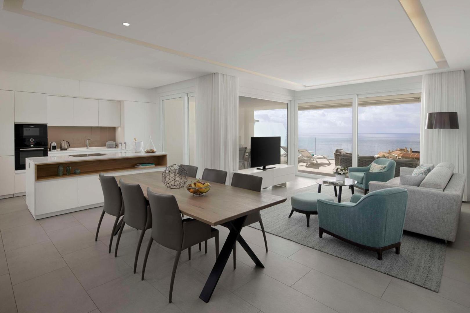 Royal Hideaway Corales Suites plašs dzīvojamais numurs ar virtuves zonu, ēdamgaldu un panorāmas logiem uz jūru Tenerifē