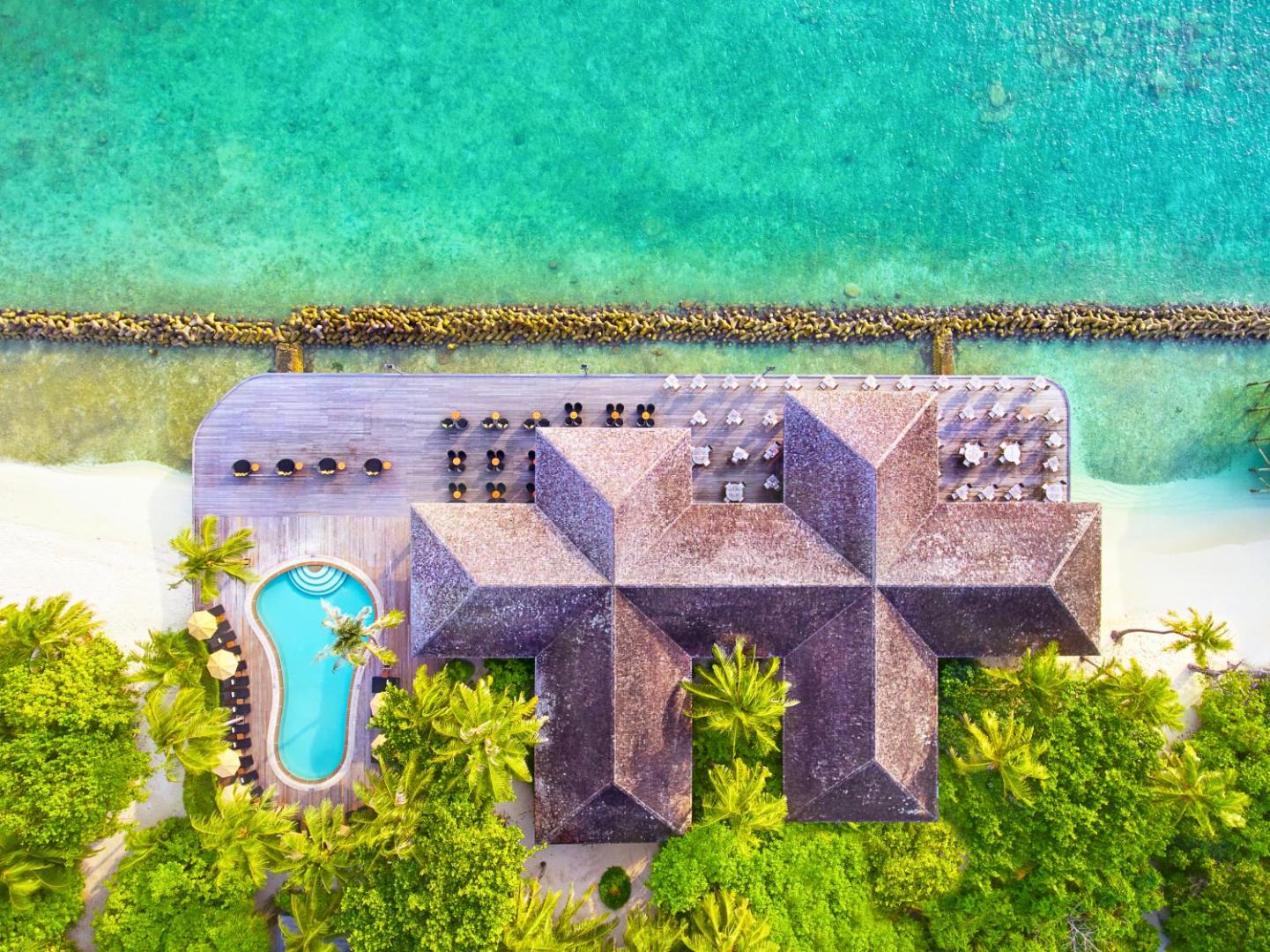 Kuredu Island Resort & Spa restorāna un terases skats no augšas ar nelielu baseinu un apkārtējo tropu zaļumu