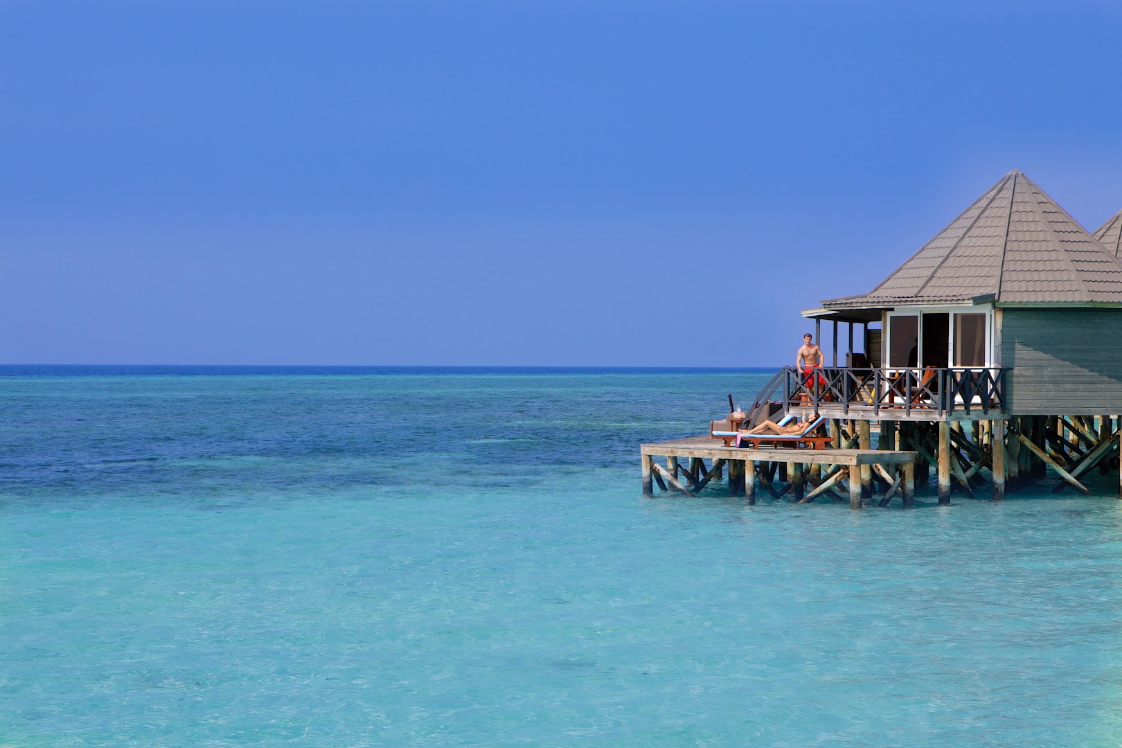 Kuredu Island Resort & Spa koka bungalo uz pāļiem okeānā ar privātu terasi un tiešu piekļuvi ūdenim
