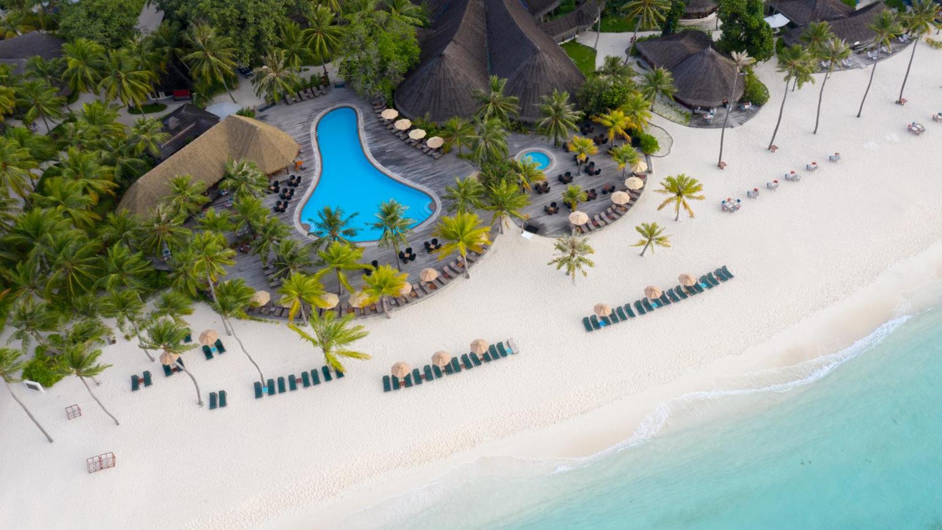 Kuredu Island Resort & Spa aerofoto ar baseinu, balto smilšu pludmali, saulessargiem un tirkīza ūdeni Maldīvu salās