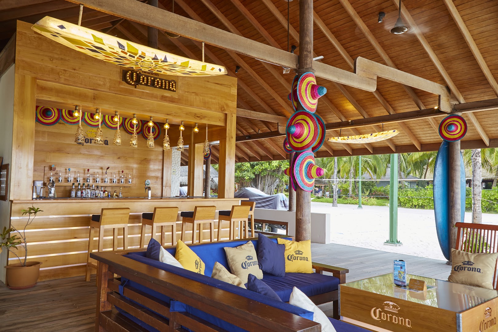 Kuredu Island Resort & Spa pludmales bārs ar koka apdari, sombrēro cepurēm un ērtu atpūtas zonu Maldīvu salās