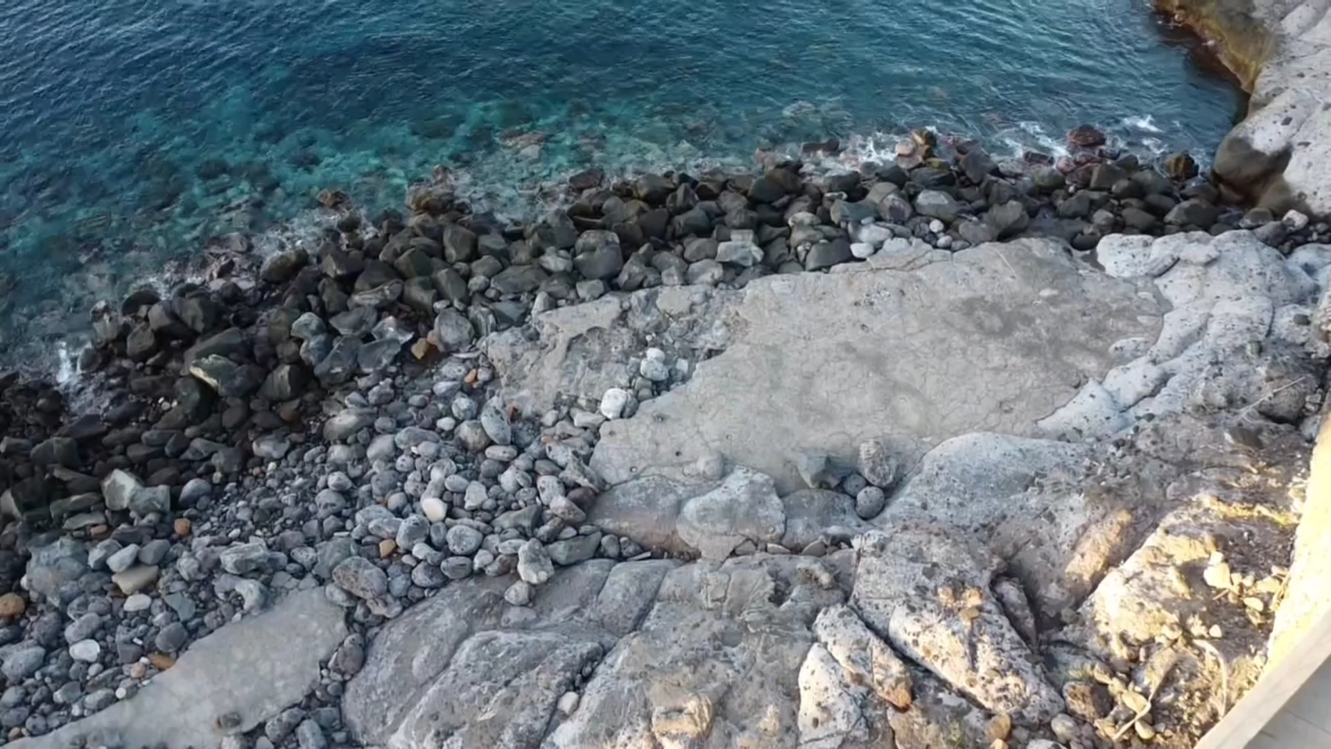 Skats no augšas uz akmeņaino piekrasti un dzidro okeāna ūdeni pie Roca Nivaria viesnīcas Tenerifes dienvidu daļā