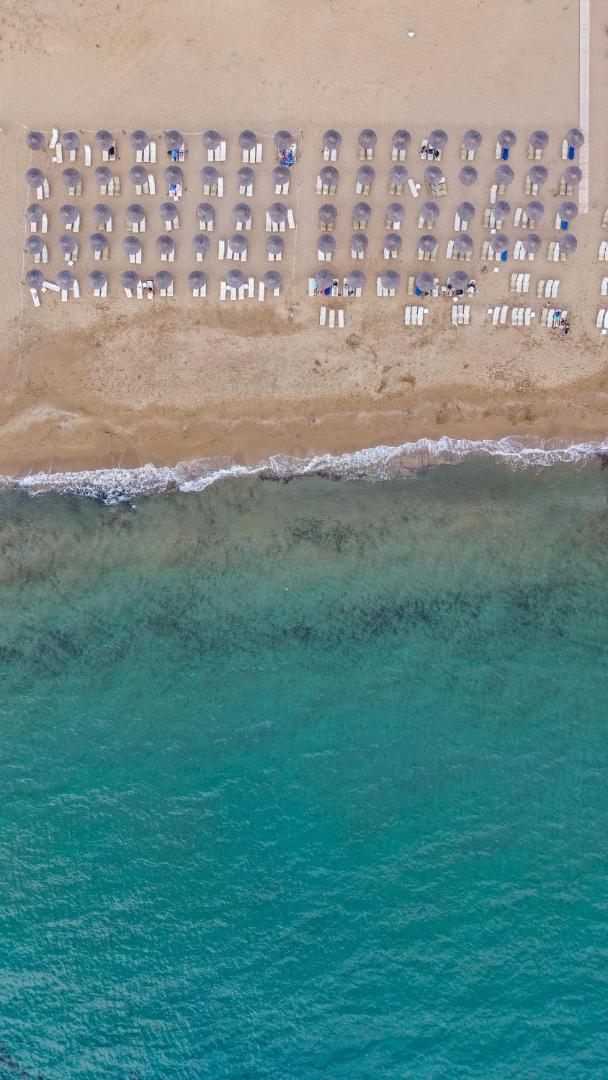 Sandy Beach Resort skats no putna lidojuma uz privāto smilšu pludmali, saulessargiem un dzidro tirkīza krāsas jūras ūdeni piekrastē.