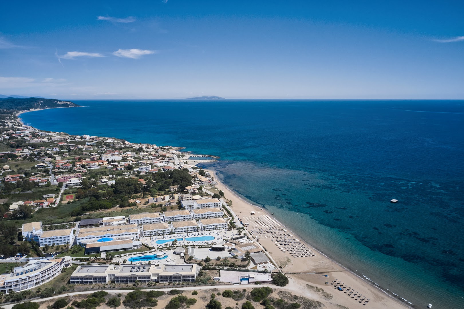 Sandy Beach Resort atrašanās vieta piekrastē Korfu salā — skats uz garo smilšu pludmali un zilo Jonijas jūru