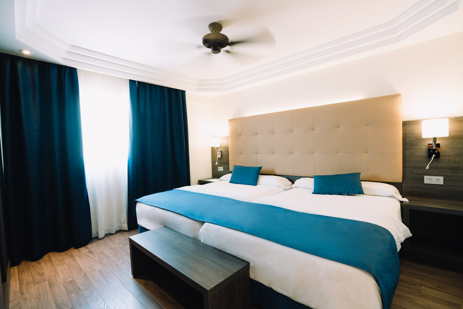 Park Club Europe gaišs viesnīcas numurs ar divguļamo gultu, ziliem akcentiem un koka grīdu Tenerifē.