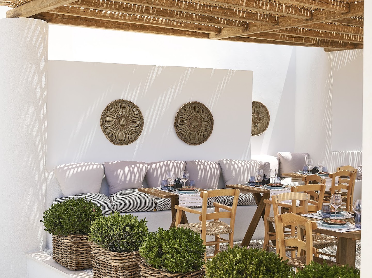 Grecotel La Riviera mājīgs ēdienkartes restorāns ar pītiem dekoriem un koka mēbelēm — gaišs interjers Vidusjūras noskaņās