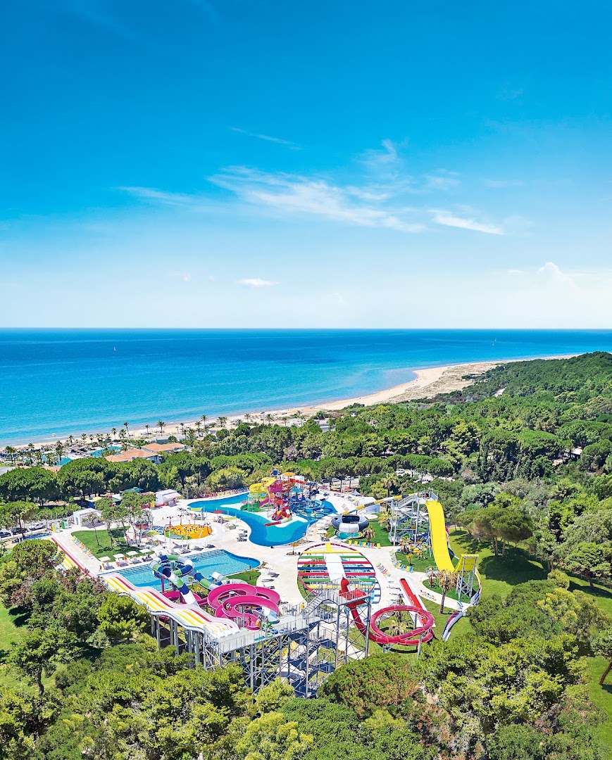 Grecotel La Riviera Olympia & Aqua Park aerofoto ar plašo akvaparku, priežu mežu un smilšu pludmali Peloponēsas piekrastē.