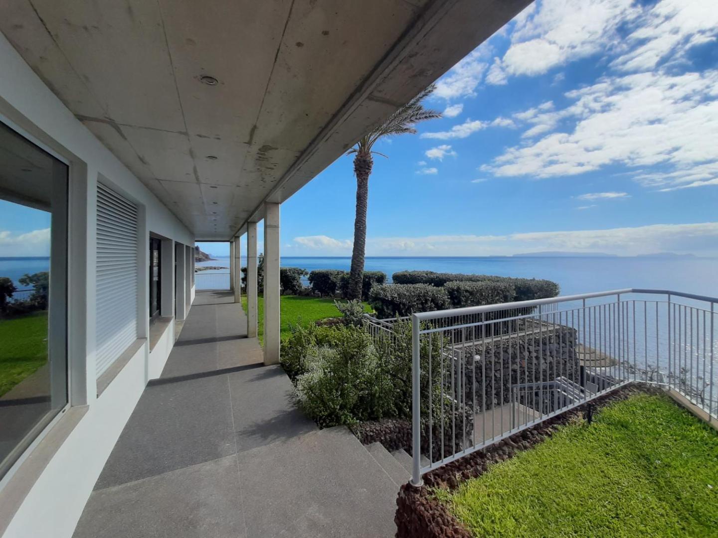 Rocamar Lido Resort atpūtas zona ar stikla margām un skatu uz okeānu — moderna arhitektūra piekrastē