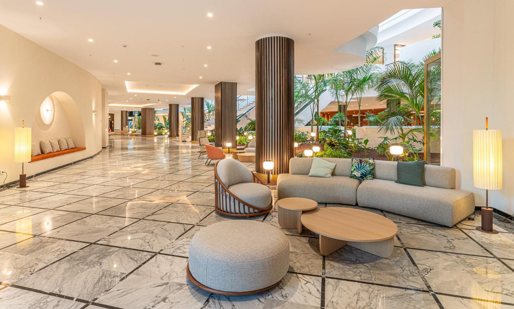 Mediterranean Palace viesnīcas lobby zona ar marmora grīdu un tropiskiem augiem — plaša uzņemšanas telpa ar ērtiem dīvāniem