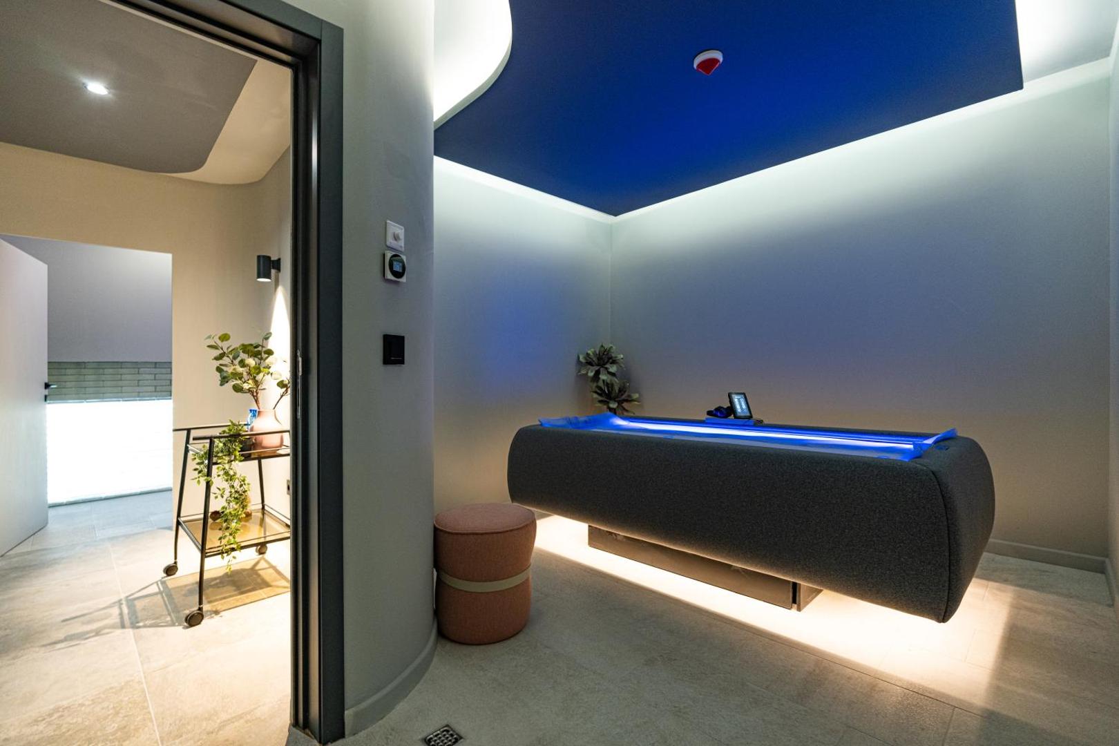 HVD Reina del Mar spa centra procedūru telpa ar modernu masāžas galdu un zilu apgaismojumu relaksējošai atmosfērai Bulgārijas kūrortā