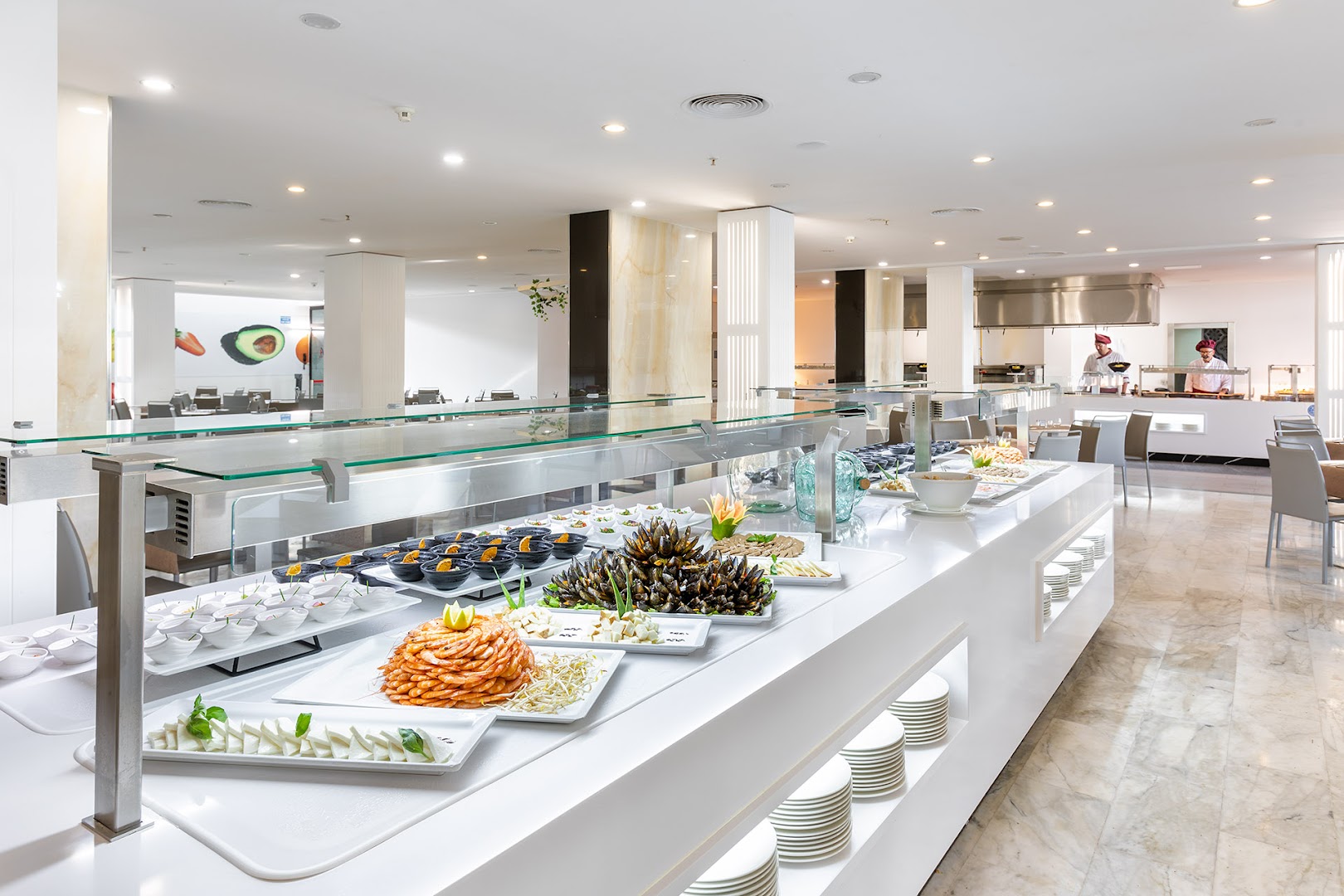 Alexandre Hotel La Siesta restorāna bufetes zona ar jūras veltēm, garnelēm un mīdijām uz balta, moderna galda