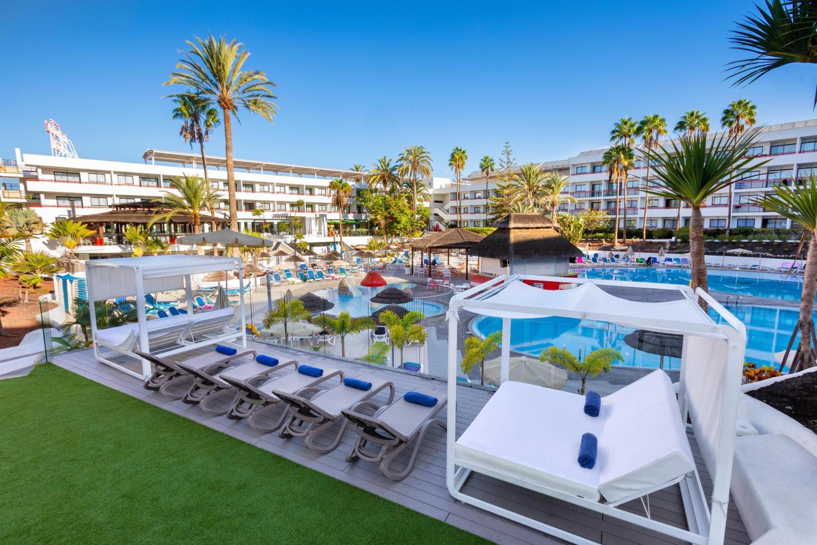 Alexandre Hotel La Siesta plašā atpūtas zona ar baseiniem, palmām un moderniem zviļņiem Tenerifē, Playa de las Americas kūrortā