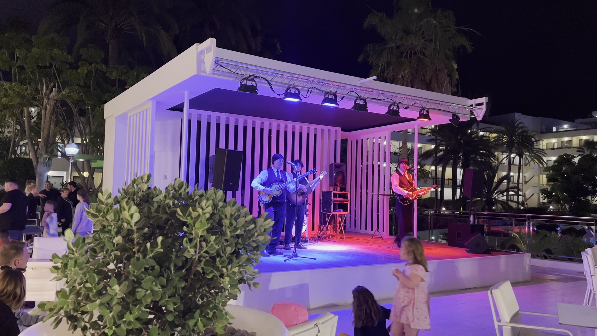 Alexandre Hotel La Siesta vakara izklaides programma Tenerifē — dzīvās mūzikas grupa uzstājas uz brīvdabas skatuves pie viesnīcas baseina