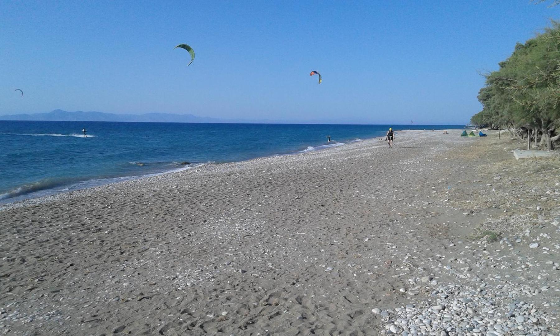 Nirvana Beach Hotel oļu un smilšu pludmales līnija ar kaitbordistiem tālumā — mierīga pastaiga gar jūras krastu Rodā