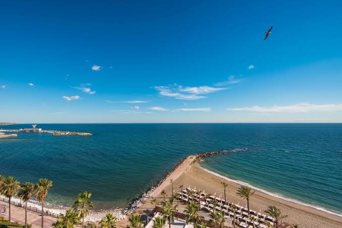 Amare Beach Hotel Marbella skats no augšas uz piekrasti, smilšu pludmali un Vidusjūras zilgmi saulainā dienā