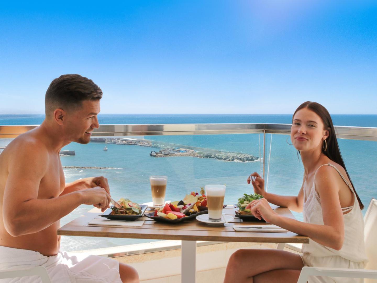 Amare Beach Hotel Marbella viesi bauda brokastis uz balkona ar skatu uz Vidusjūru — galds ar augļiem un kafiju