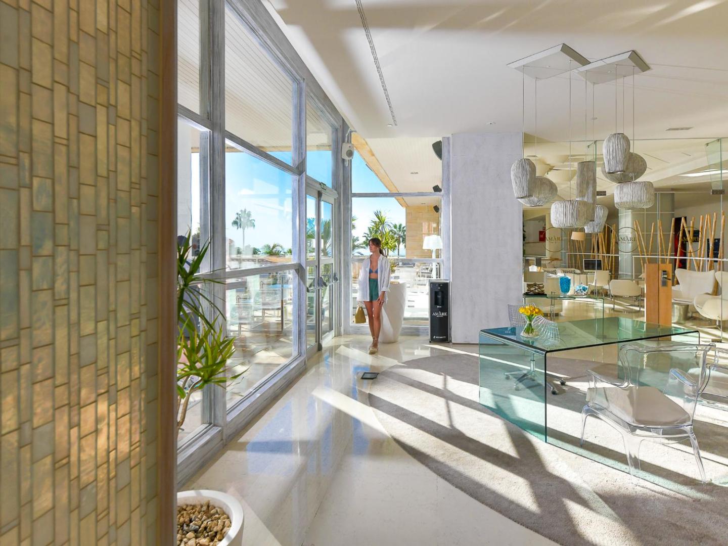 Gaišs un plašs Amare Beach Hotel Marbella vestibils ar stikla sienām, dizaina elementiem un skatu uz āra terasi