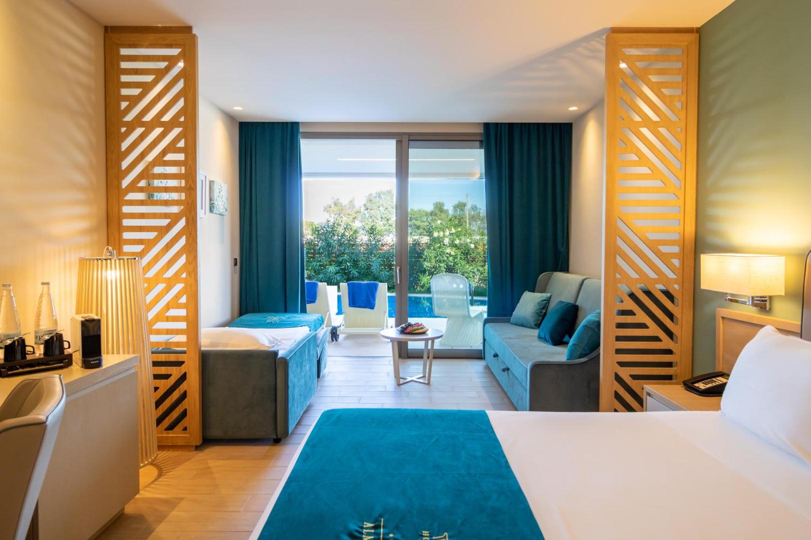 Almyros Beach Resort & Spa numurs ar tiešu piekļuvi baseinam, atpūtas zonu ar dīvānu un sauļošanās krēsliem uz terases