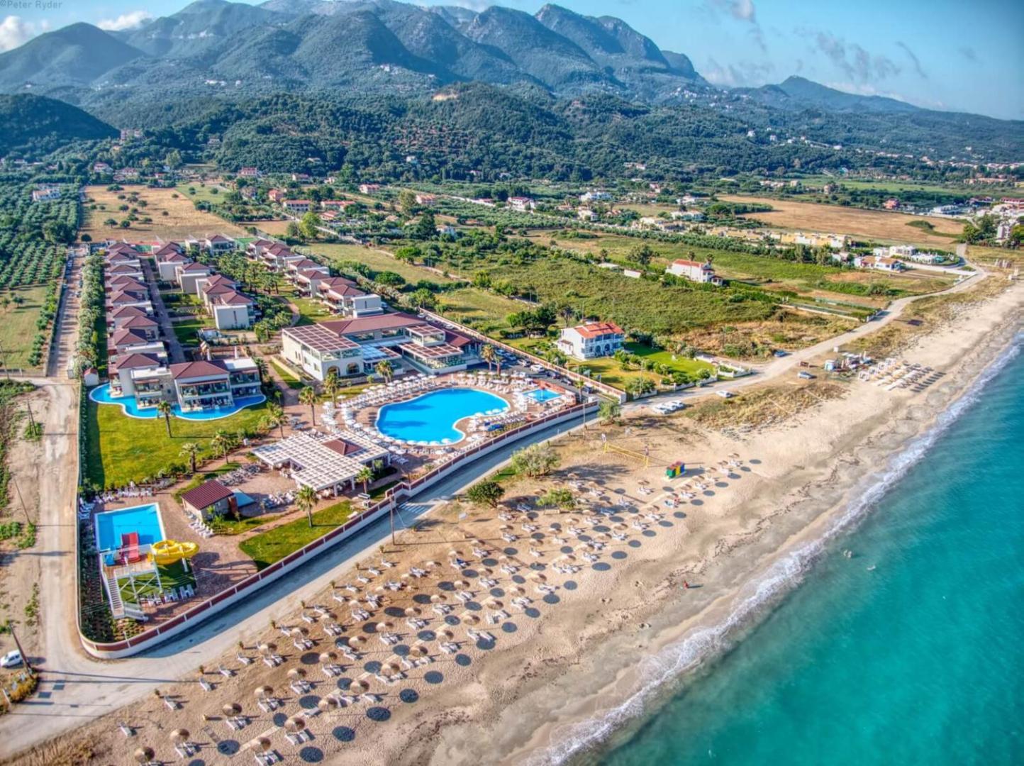 Almyros Beach Resort & Spa skats no putna lidojuma uz baseinu kompleksu un smilšu pludmali Korfu salas ziemeļos, Grieķijā