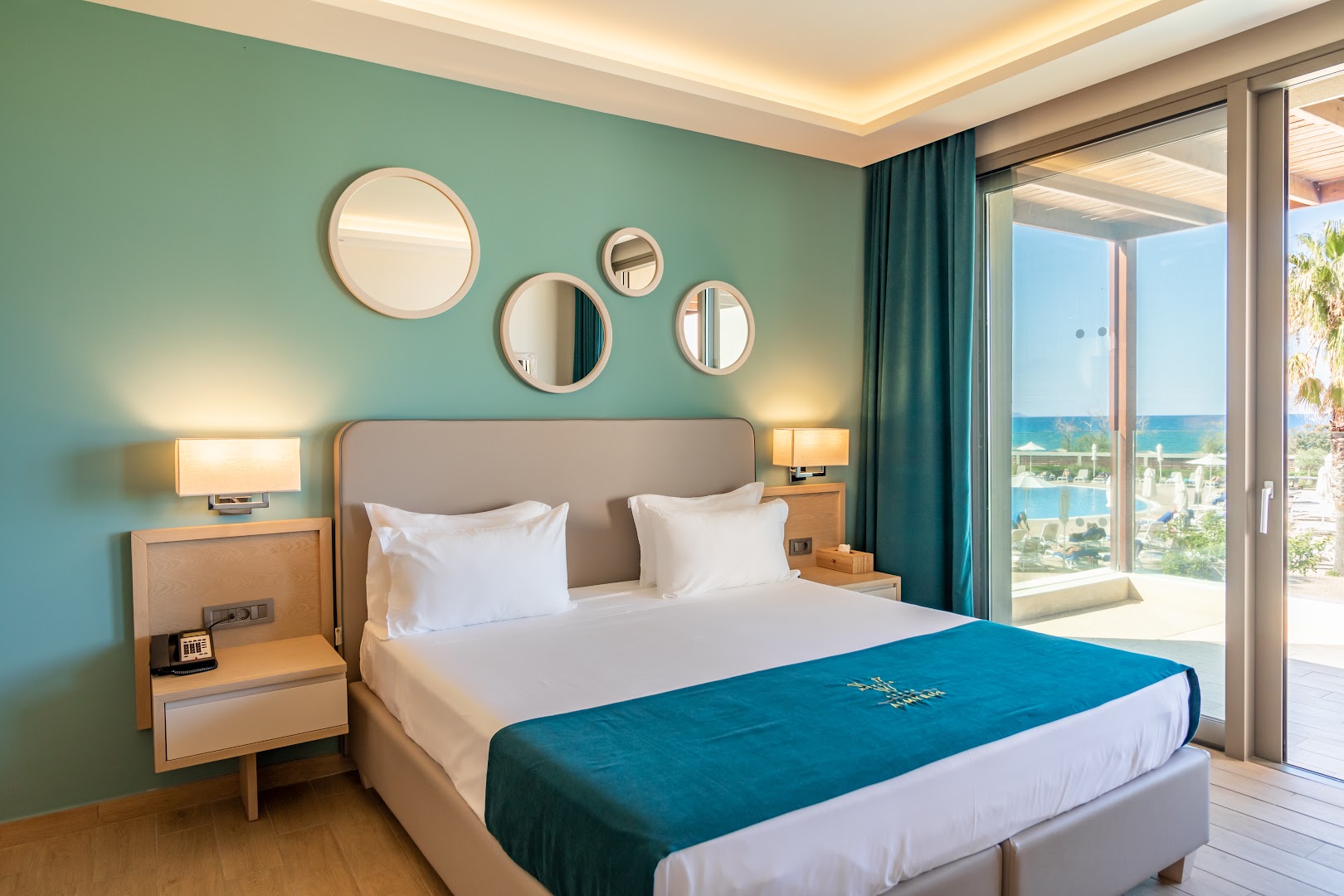 Almyros Beach Resort & Spa gaišs numurs ar skatu uz jūru un āra baseinu caur plašu stikla sienu Korfu piekrastē
