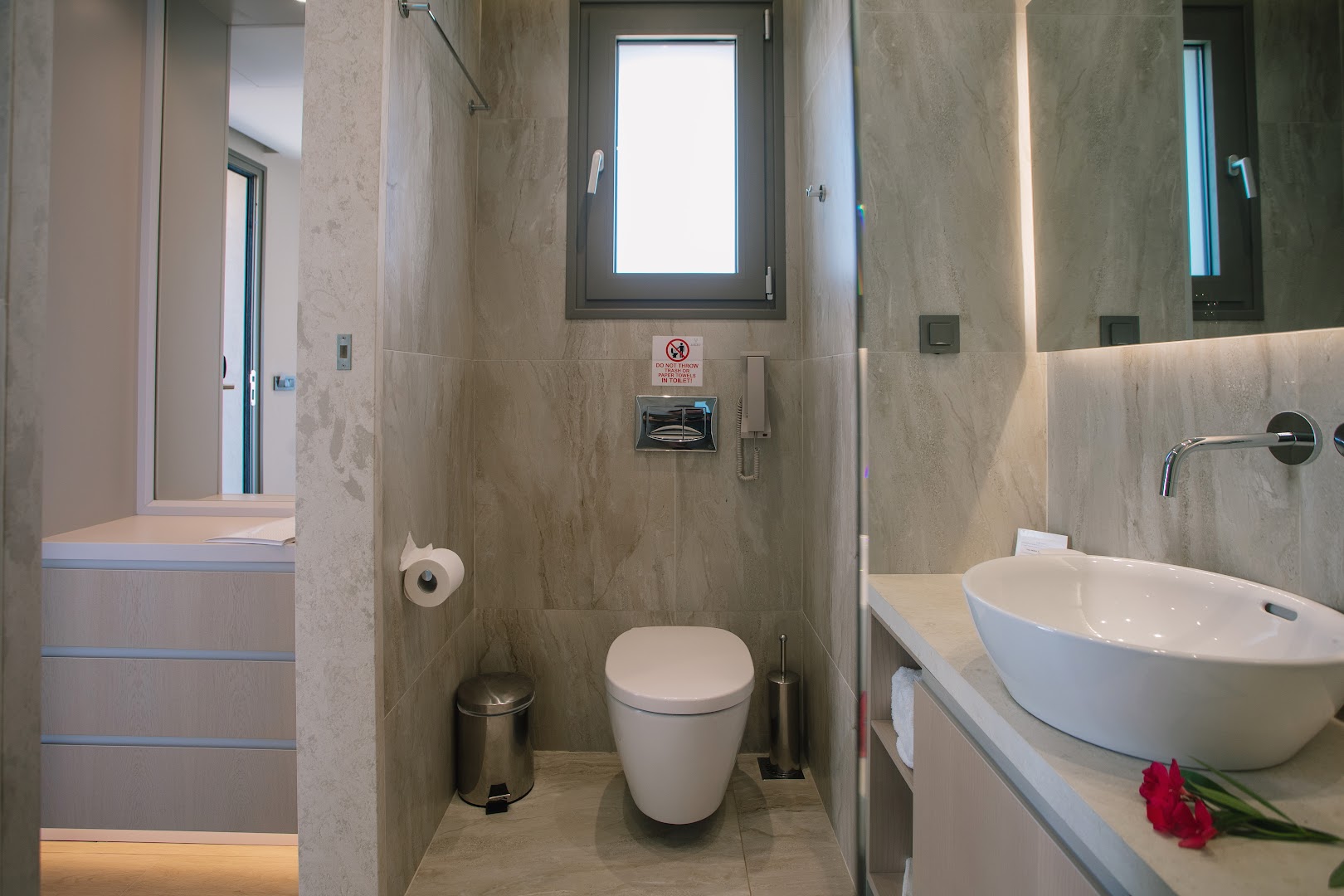 Almyros Beach Resort & Spa numura vannas istabas interjers ar modernu izlietni, tualeti un akmens tekstūras flīzēm Korfu viesnīcā