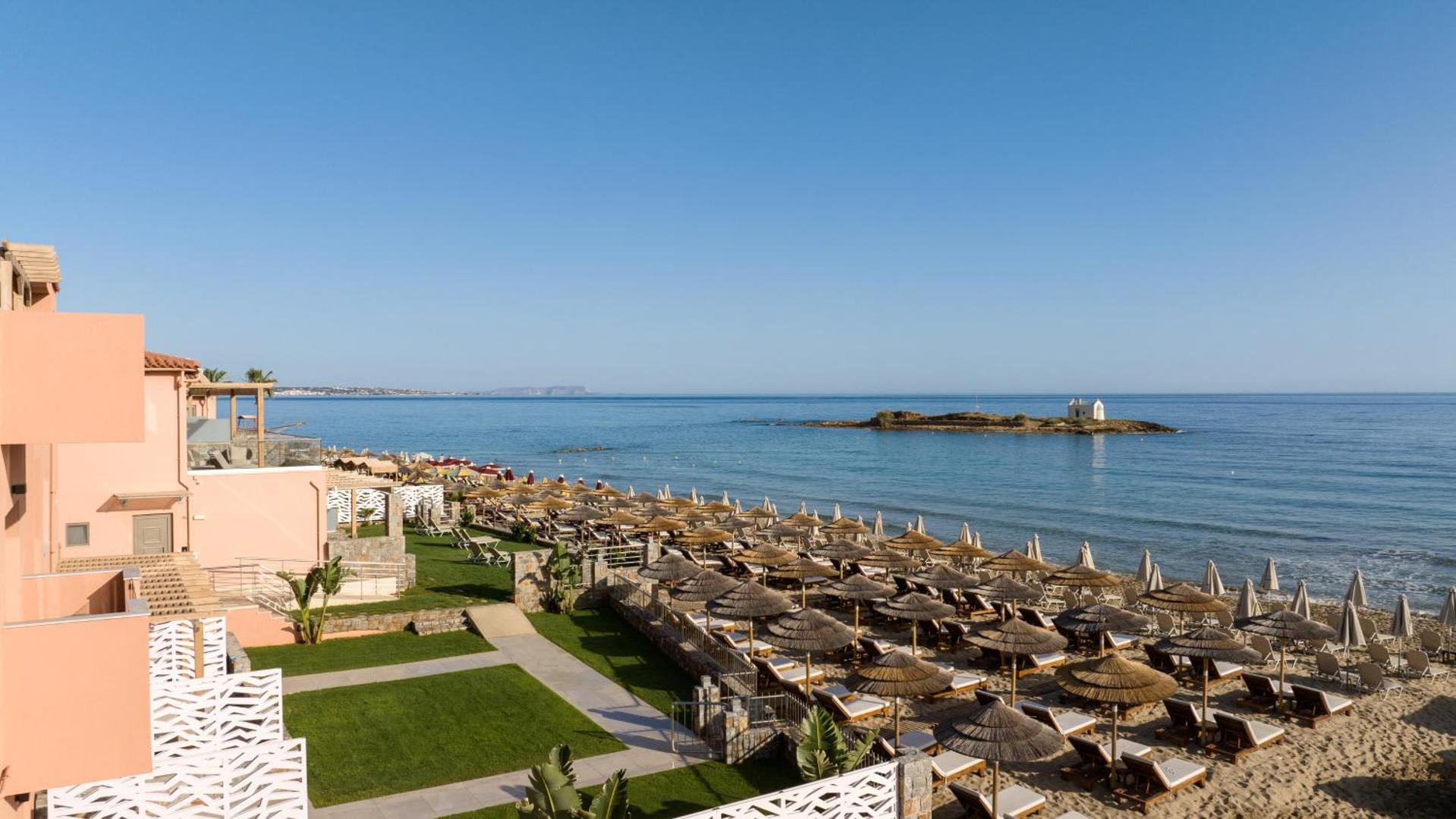 High Beach Resort skats no augšas uz viesnīcas teritoriju, zālājiem un pludmali ar salmu saulessargiem Malijas piekrastē