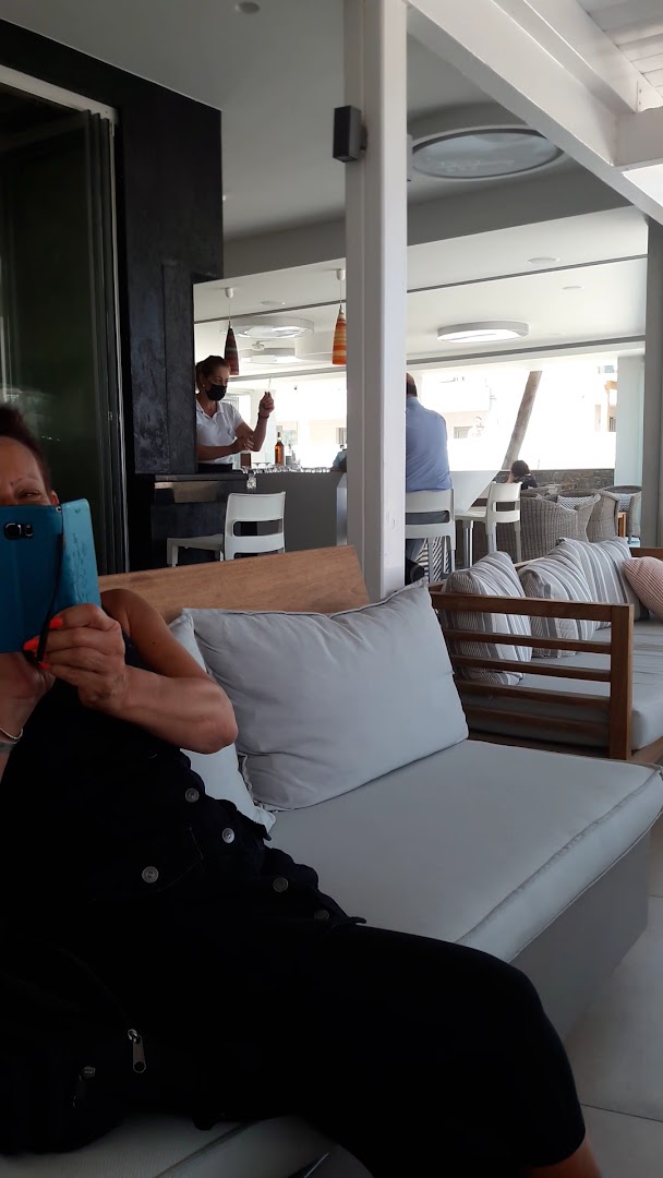 High Beach Resort atpūtas zona ar mīkstiem dīvāniem un skatu uz bāru, kur viesi bauda relaksējošu atmosfēru.