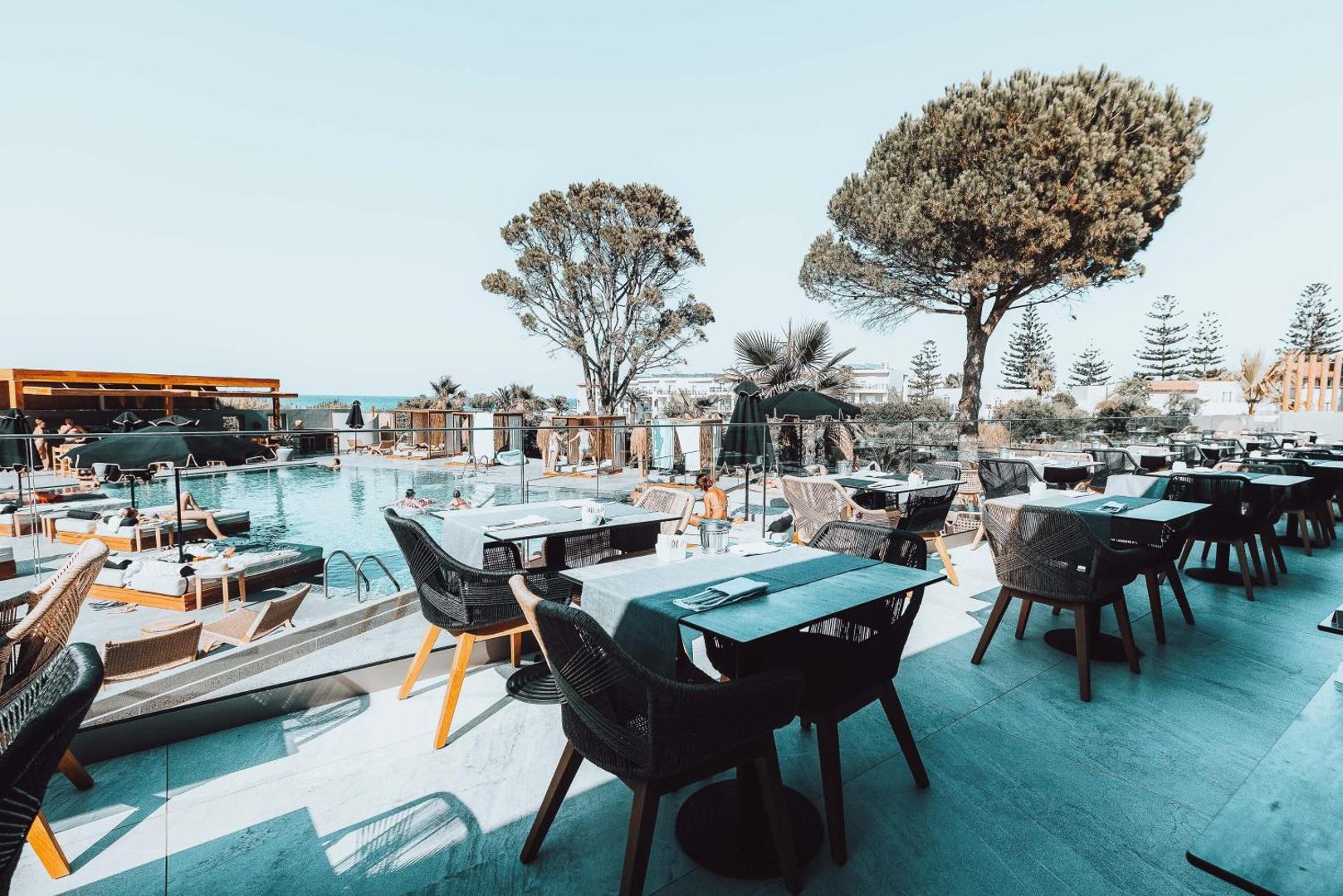Eliros Mare Beachfront Poem Hotel āra terases restorāns ar skatu uz baseinu un jūru Georgiupoli, Krētā — moderni galdi un krēsli