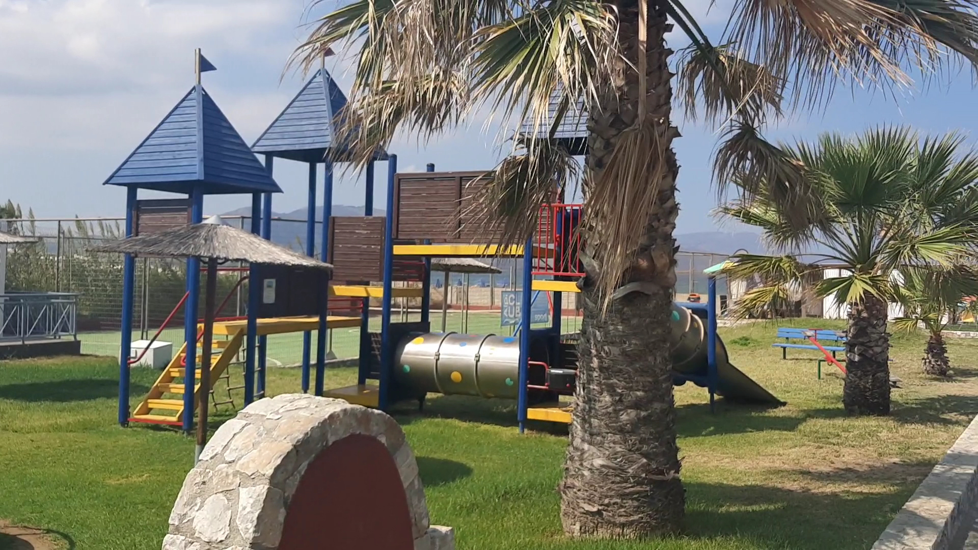 Eliros Mare Beachfront Poem Hotel bērnu rotaļu laukums uz zālāja ar slidkalniņiem un kāpšļiem Georgiupoles piekrastē