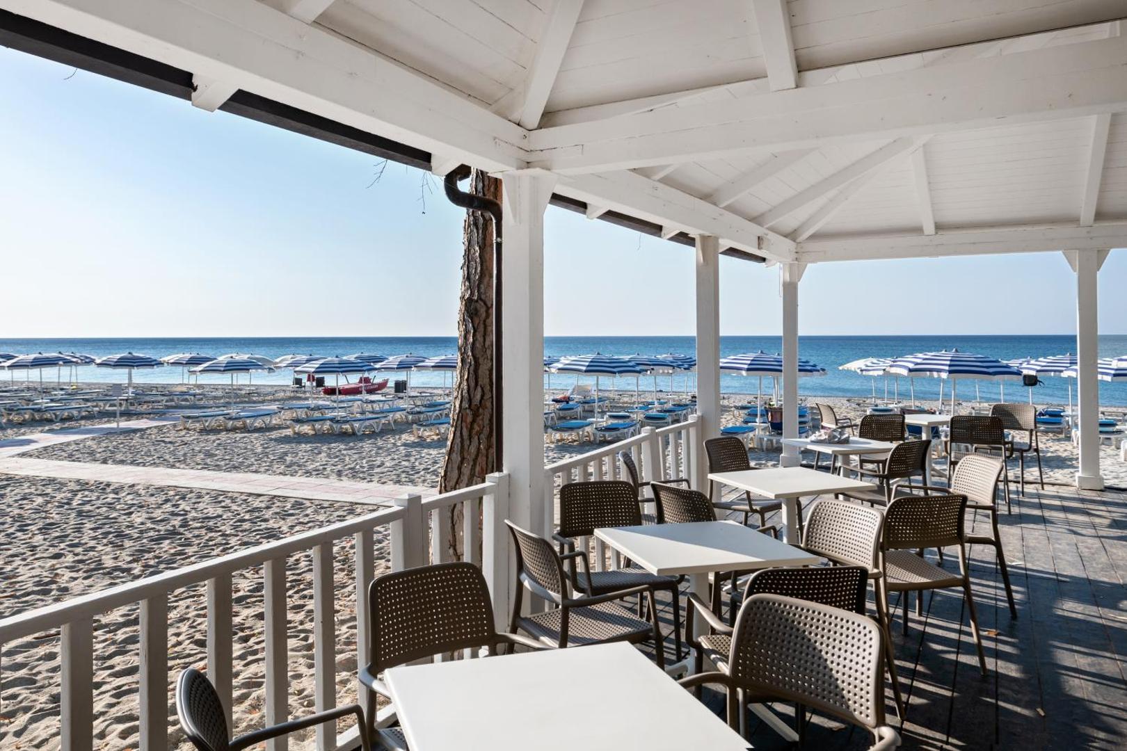 VOI Floriana Resort pludmales bārs ar skatu uz Jonijas jūru un saulessargu zonu smilšu pludmalē
