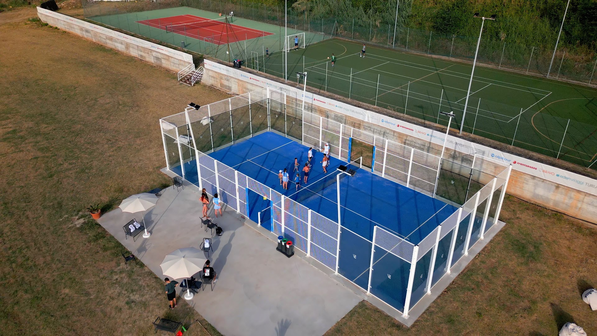VOI Le Muse Essentia sporta infrastruktūra ar padela tenisa kortu, futbola laukumu un tenisa kortiem fonā