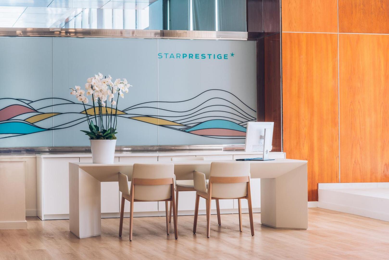 Iberostar Waves Bouganville Playa Star Prestige zonas reģistratūra ar modernu baltu galdu un orhidejām — elegants interjers Tenerifes viesnīcā