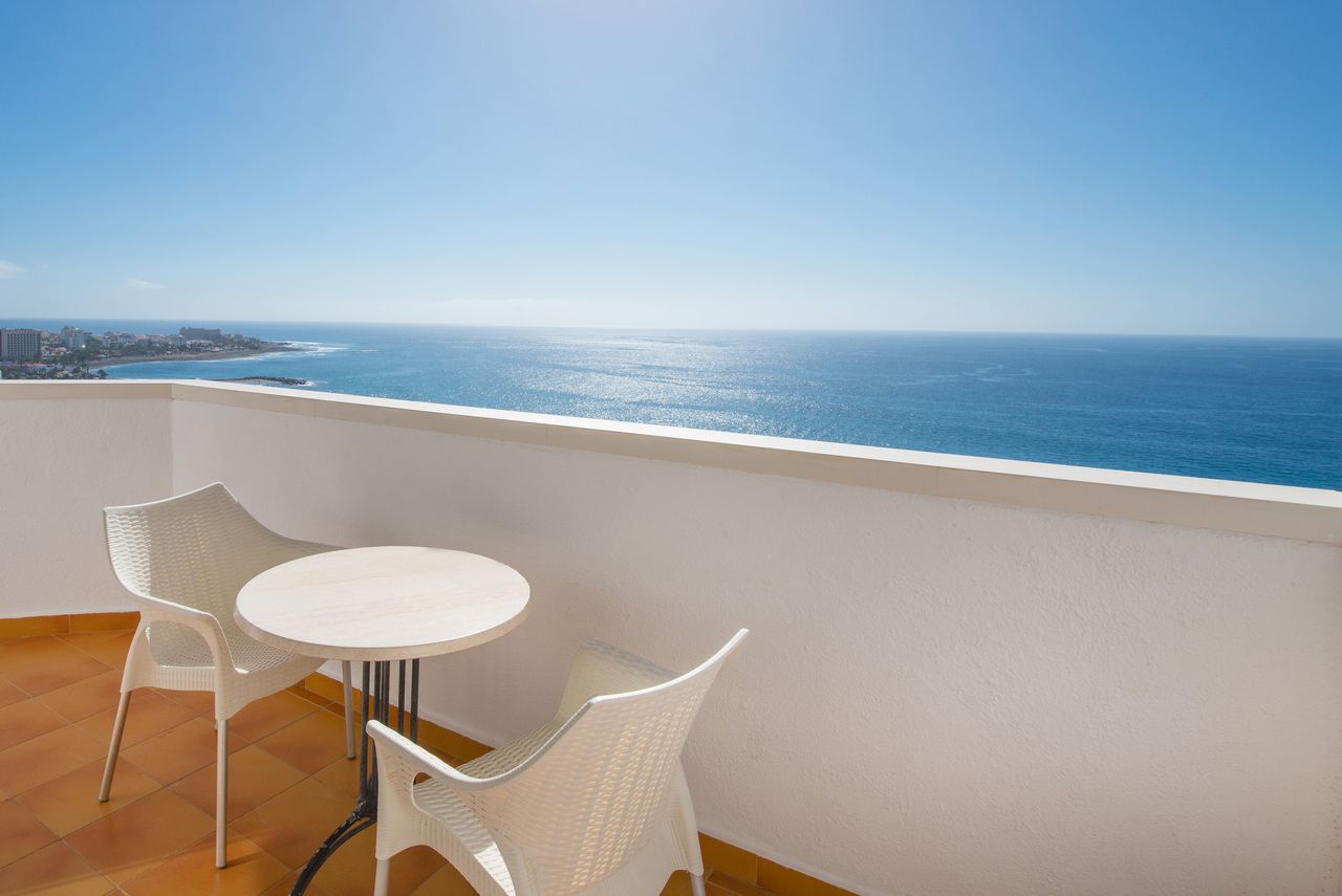 Skats no Iberostar Waves Bouganville Playa balkona uz zilo okeānu un horizontu saulainā dienā Tenerifē
