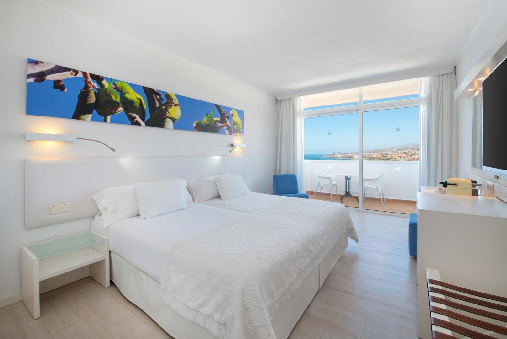 Iberostar Waves Bouganville Playa gaišs viesnīcas numurs ar divguļamo gultu, balkonu un skatu uz okeānu Tenerifē, Kanāriju salās