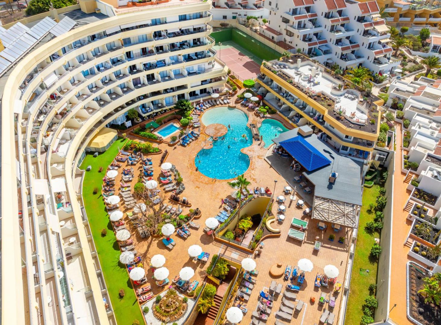 Hovima Santa Maria viesnīcas iekšpagalms no augšas Tenerifē — redzami vairāki baseini, sauļošanās zonas, bārs un tenisa korti