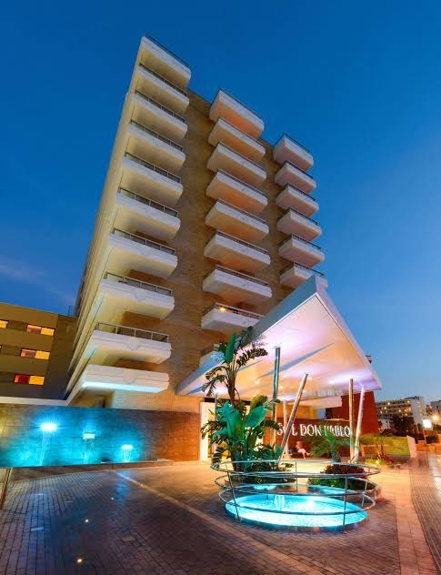 Sol Torremolinos Don Pablo viesnīcas modernā fasāde un ieeja ar izgaismotu strūklaku vakara stundā Kostadelasolā