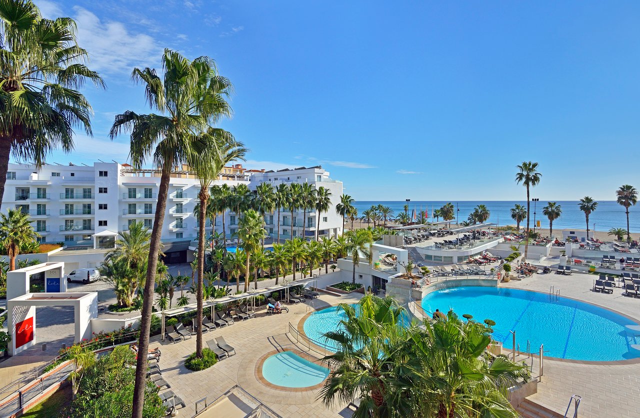 Sol Torremolinos Don Pablo viesnīcas teritorija ar vairākiem āra baseiniem, palmām un skatu uz Vidusjūru Torremolinosā, Spānijā