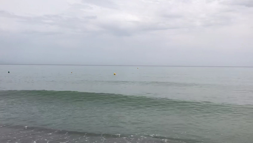 Vidusjūras piekraste pie Sol Torremolinos Don Pablo viesnīcas ar mierīgiem viļņiem un mākoņainām debesīm