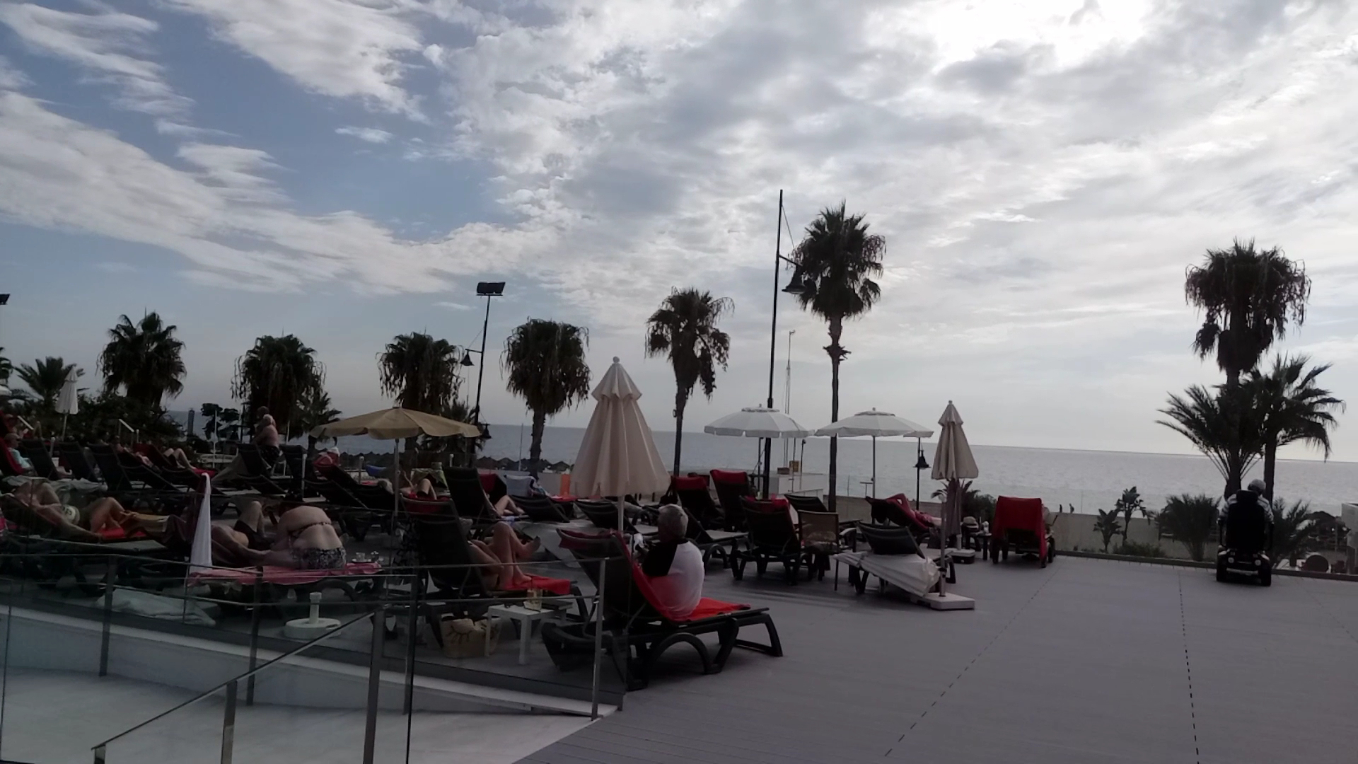 Sol Torremolinos Don Pablo atpūtas terase ar sauļošanās krēsliem, saulessargiem un skatu uz jūru palmu pavēnī