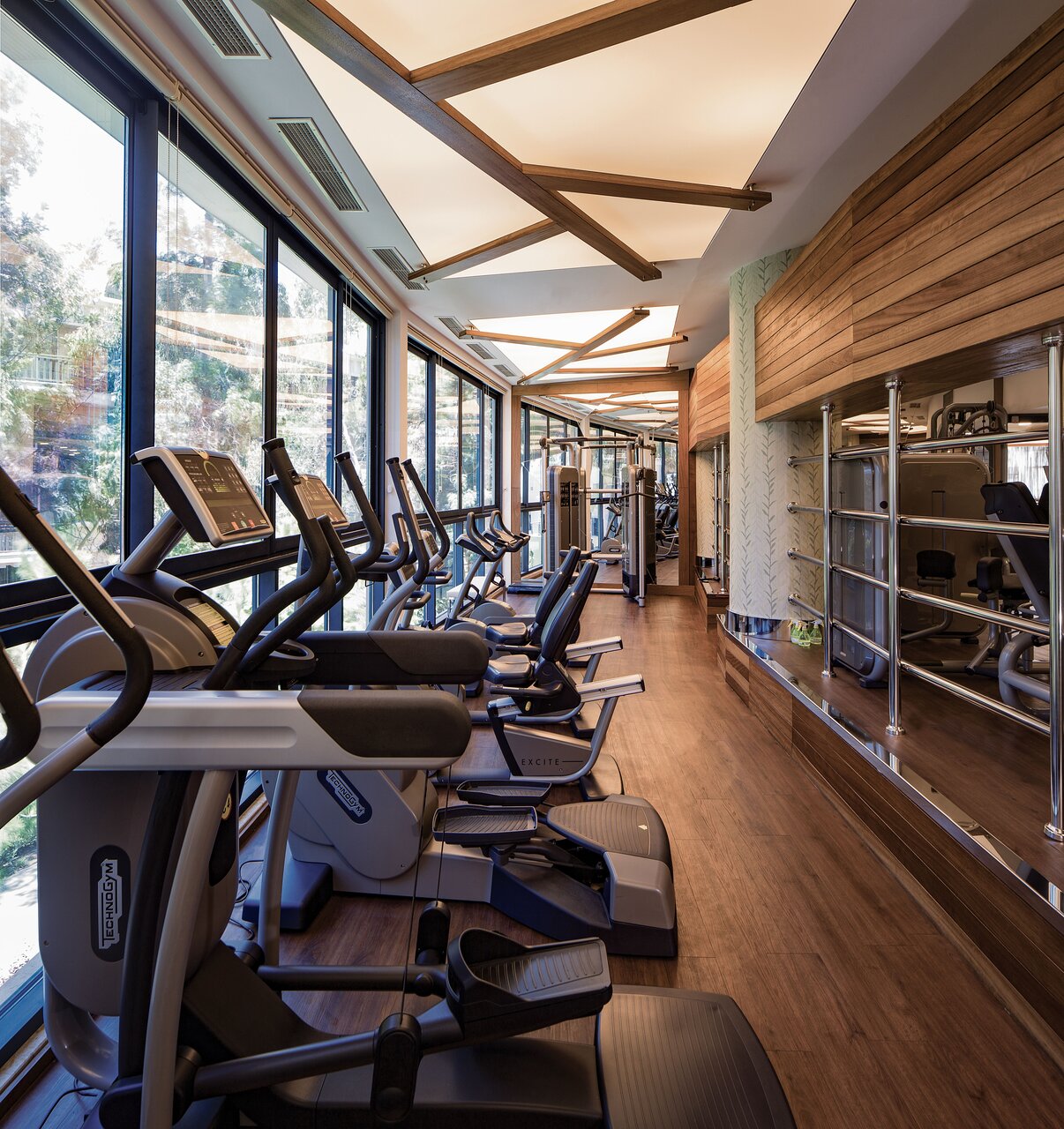 Paloma Sencia fitness centrs ar moderniem trenažieriem un lieliem logiem ar skatu uz dārzu, Beleka